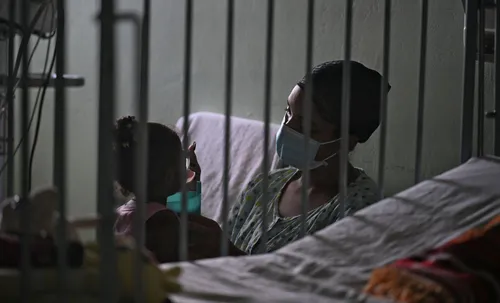 A woman cares for her daughter at a hospital in Havana