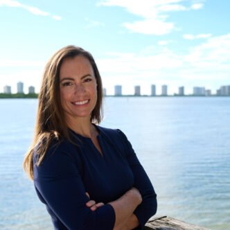 Democrat Emily Gregory smiling, with a background of the Florida statehouse