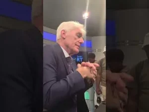 Hugo Broos in a navy suit and light-blue shirt