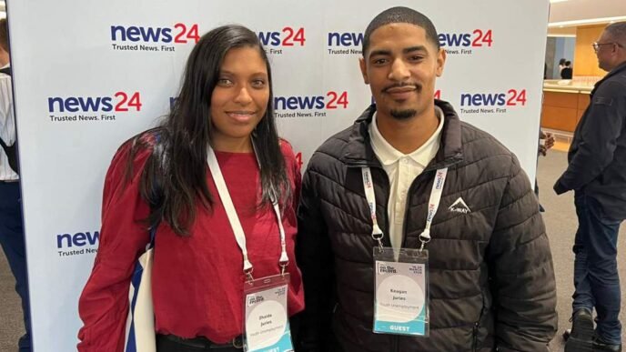 Couple smiling and shaking hands with businessman