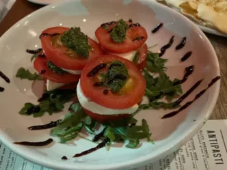 A group of friends enjoying pizza and wine together