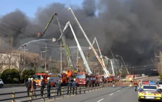 Firefighters spraying water to extinguish a fire at a car parts plant in Daejeon