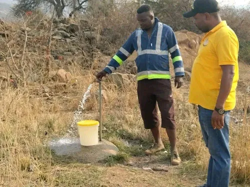 African woman collecting water from a borehole