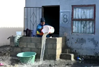 Residents of Ekupholeni informal settlement wading through floodwater