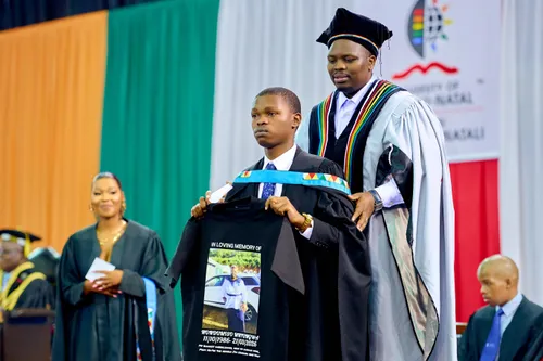 Graduate holding T-shirt with photo of mother